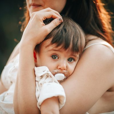 Mum cradling young child with blue eyes looking into the camera, for Life Charity Impact supporting women in unexpected pregnancy